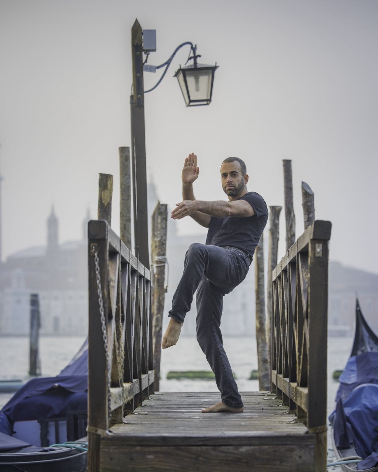 Jerome in a standing balance on a wooden pier in Venice