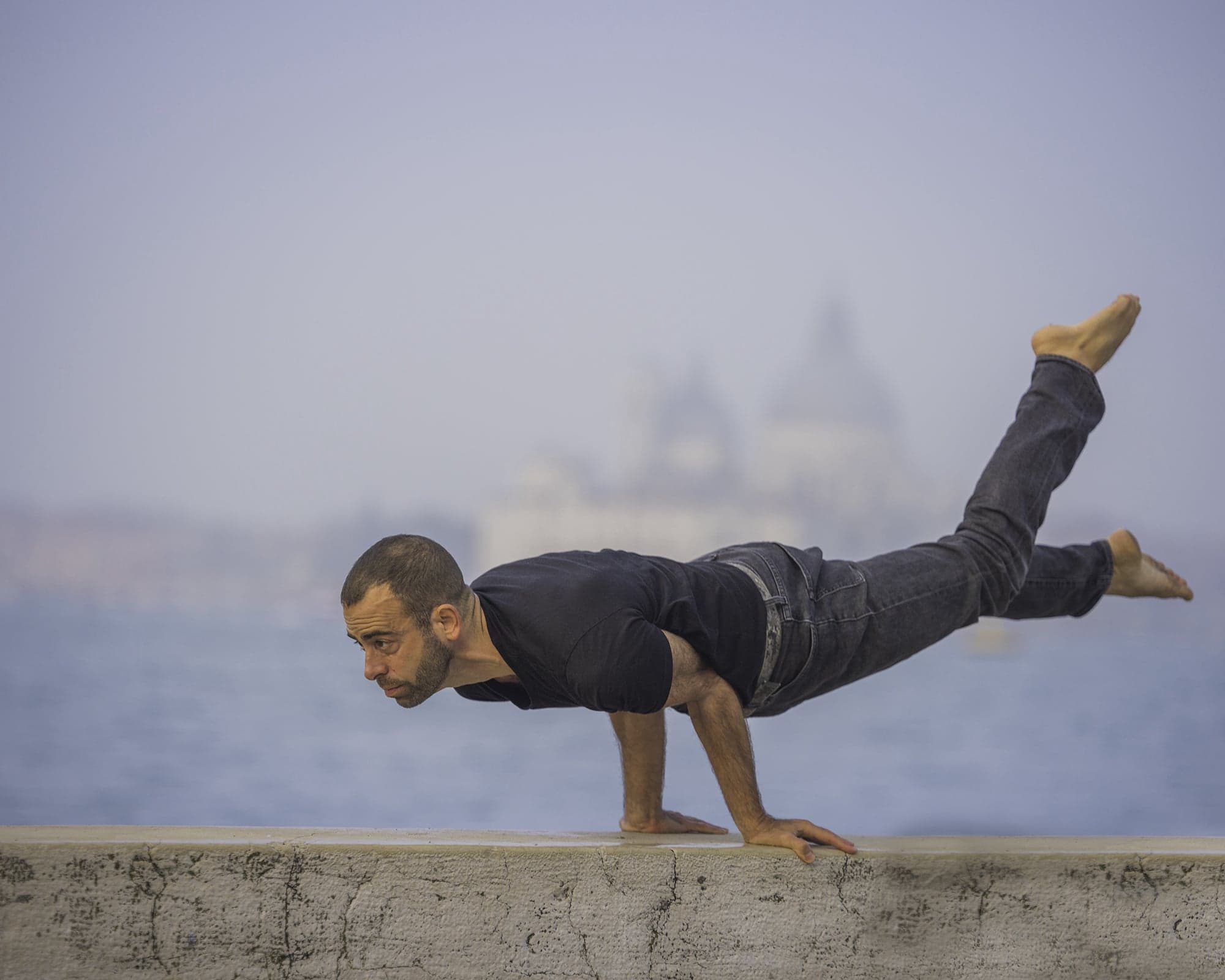 Jerome in an arm balance on a seawall in Venice